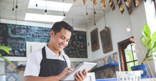 Small Business Owner Smiling at Tablet