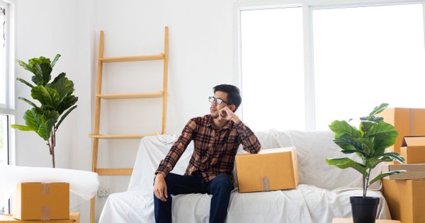 Man Sitting in Room of Moving Boxes