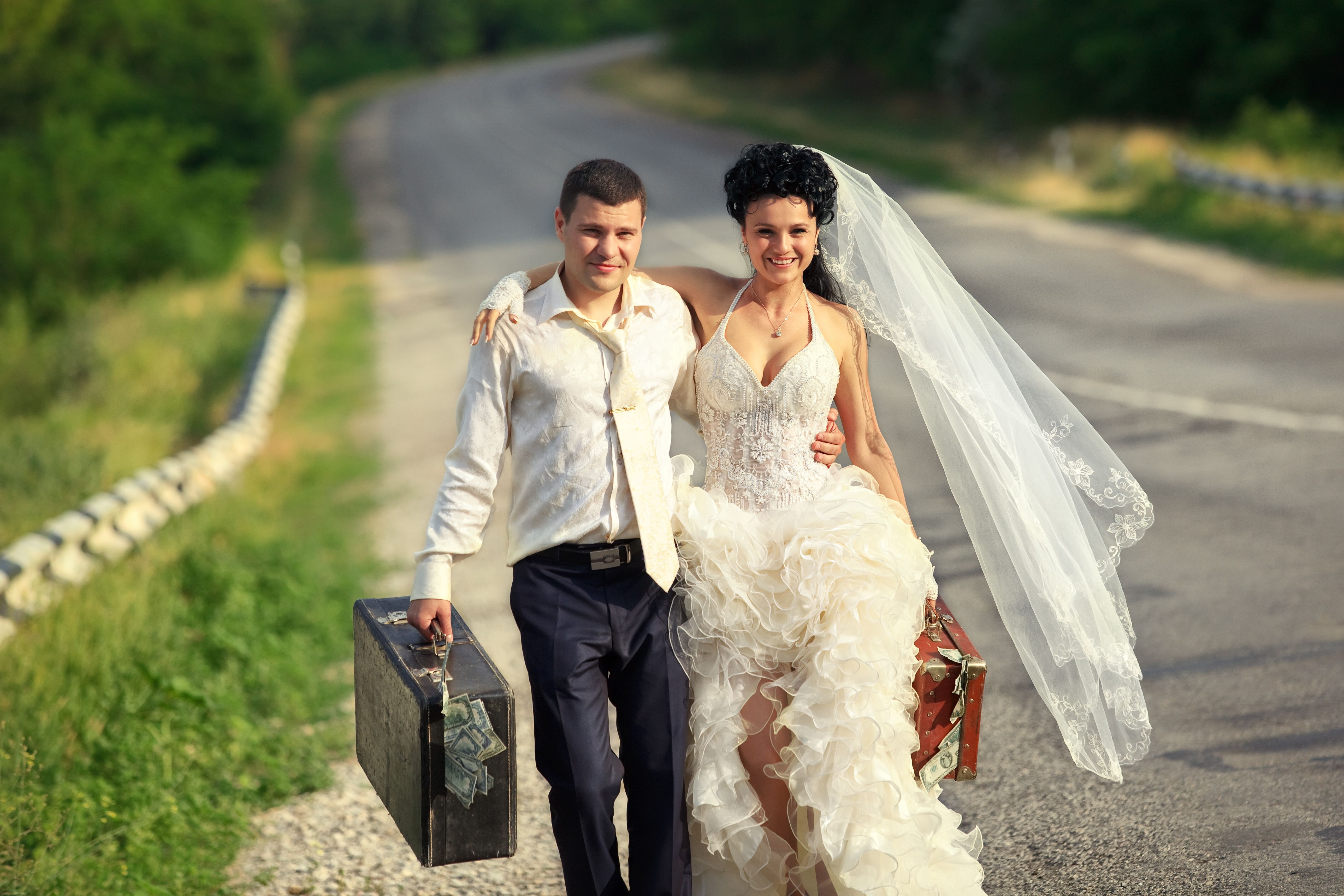 Young married couple with suitcases of cash